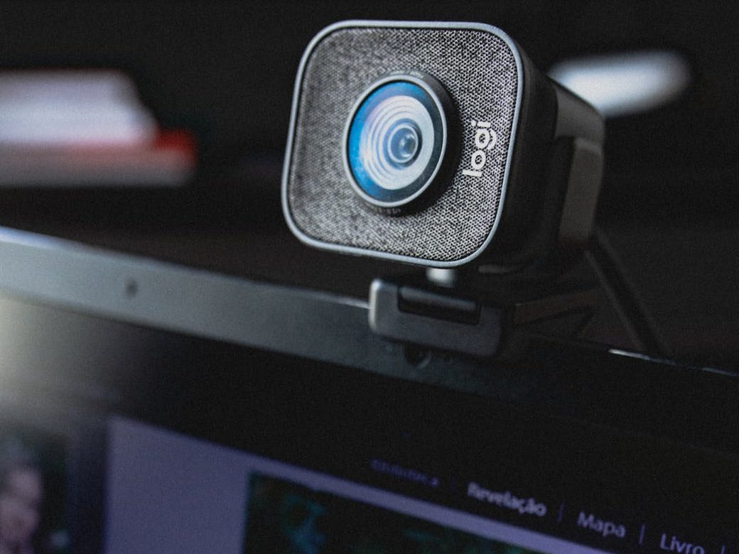 modern video camera hanging on display of laptop